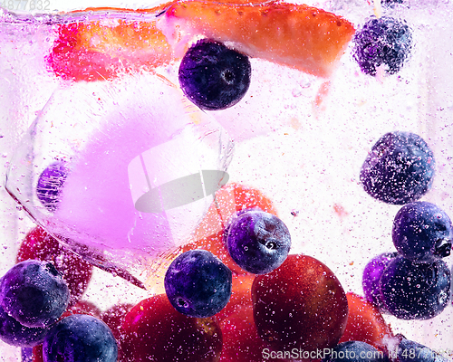 Image of Close up view of the cold and fresh lemonade with bright berries in neon light