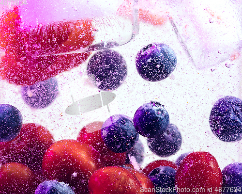 Image of Close up view of the cold and fresh lemonade with bright berries in neon light