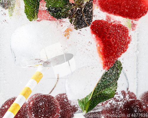 Image of Close up view of the cold and fresh lemonade with bright berries in neon light