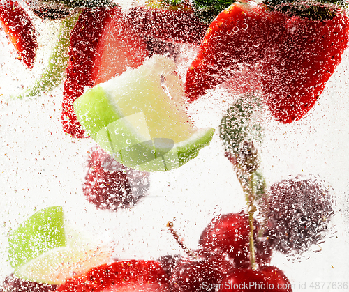 Image of Close up view of the cold and fresh lemonade with bright berries in neon light