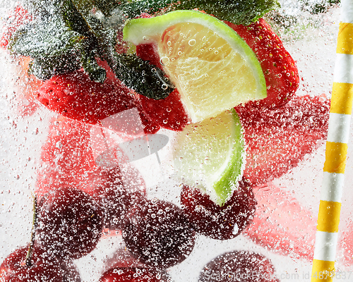 Image of Close up view of the cold and fresh lemonade with bright berries in neon light