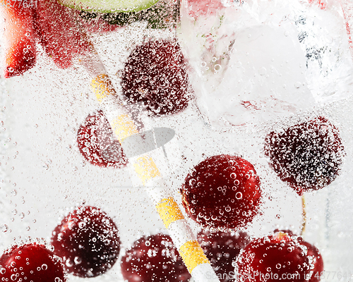 Image of Close up view of the cold and fresh lemonade with bright berries in neon light