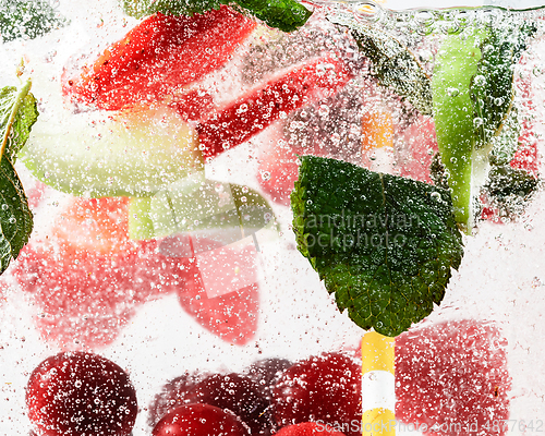 Image of Close up view of the cold and fresh lemonade with bright berries in neon light