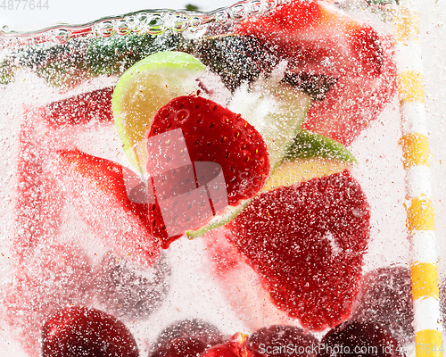 Image of Close up view of the cold and fresh lemonade with bright berries in neon light