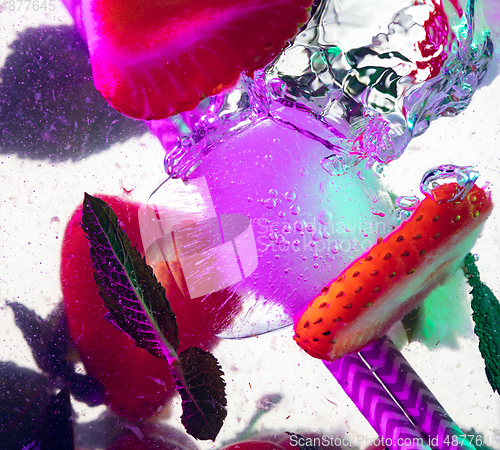 Image of Close up view of the cold and fresh lemonade with bright berries in neon light