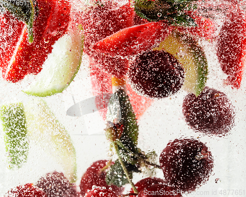 Image of Close up view of the cold and fresh lemonade with bright berries in neon light