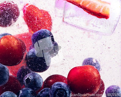 Image of Close up view of the cold and fresh lemonade with bright berries in neon light