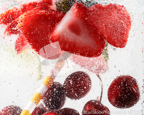 Image of Close up view of the cold and fresh lemonade with bright berries in neon light