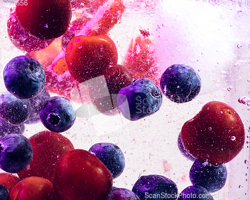 Image of Close up view of the cold and fresh lemonade with bright berries in neon light