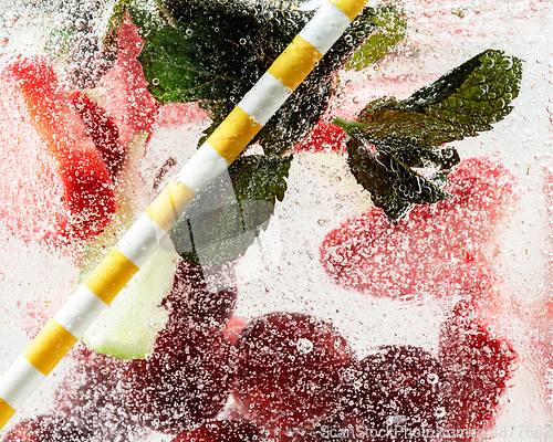 Image of Close up view of the cold and fresh lemonade with bright berries in neon light