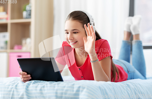 Image of girl having vide call on tablet computer at home