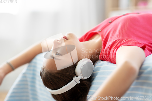 Image of girl in headphones listening to music at home