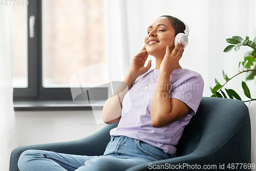 Image of woman in headphones listening to music at home