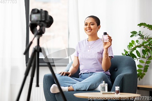 Image of female beauty blogger with camera and perfume