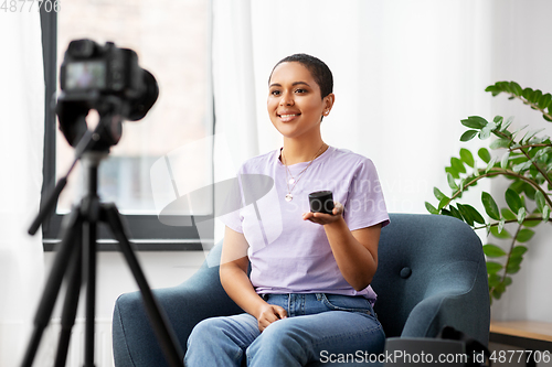 Image of female blogger with camera video blogging at home