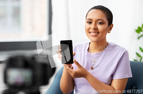 Image of female blogger with camera video blogging at home