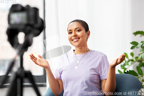 Image of female blogger with camera video blogging at home