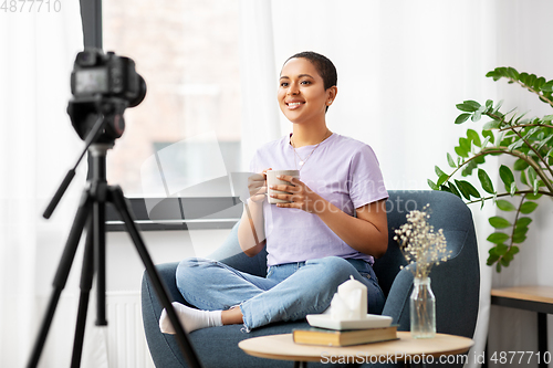 Image of female blogger with camera and coffee at home