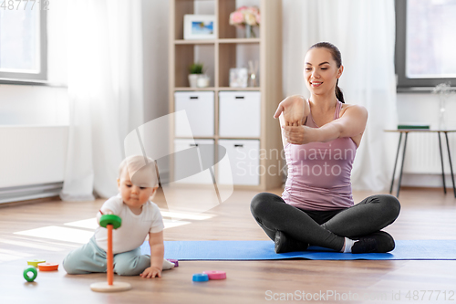 Image of happy mother with little baby exercising at home