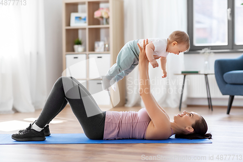 Image of happy mother with little baby exercising at home