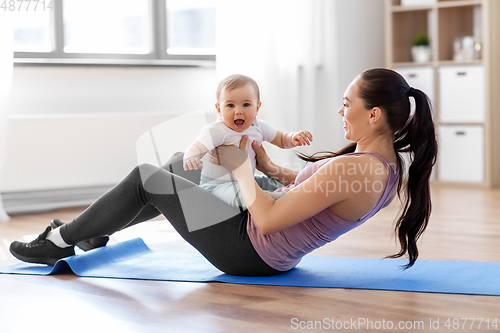 Image of happy mother with little baby exercising at home