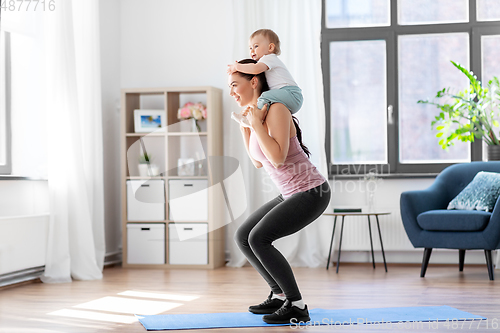 Image of happy mother with little baby exercising at home