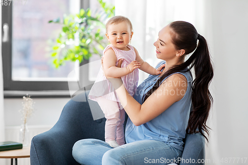 Image of happy mother with little baby daughter at home