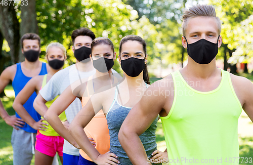 Image of group of happy friends or sportsmen at summer park