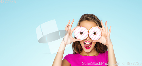 Image of happy woman or teen girl looking through donuts