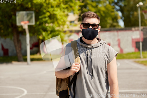 Image of man with backpack at street basketball playground