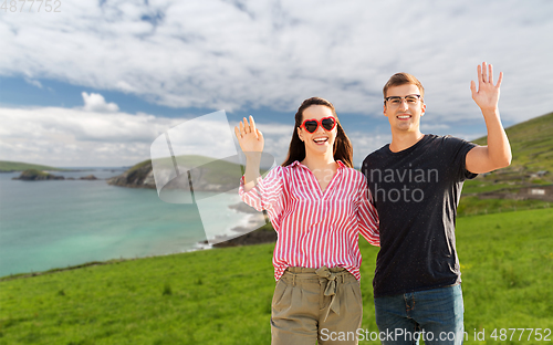 Image of happy couple waving hands in ireland