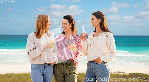 Image of young women with non alcoholic drinks on beach