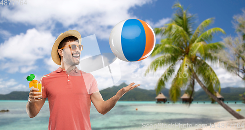 Image of happy man with orange juice and beach ball