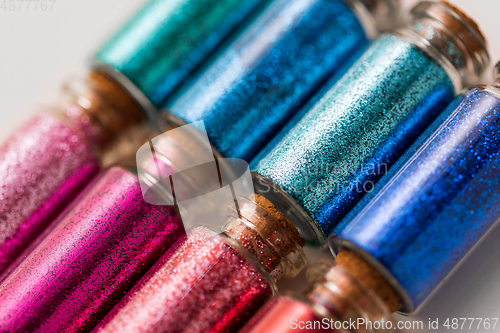 Image of set of glitters in bottles over white background