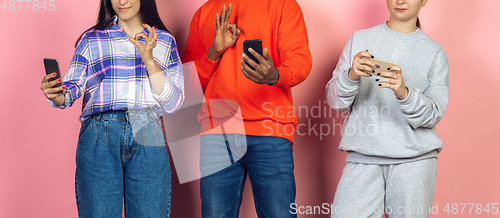 Image of Group of friends using mobile smartphones. Teenagers addiction to new technology trends. Close up.