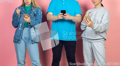 Image of Group of friends using mobile smartphones. Teenagers addiction to new technology trends. Close up.