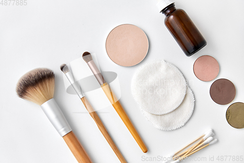 Image of make up brushes, cosmetics and cotton swabs