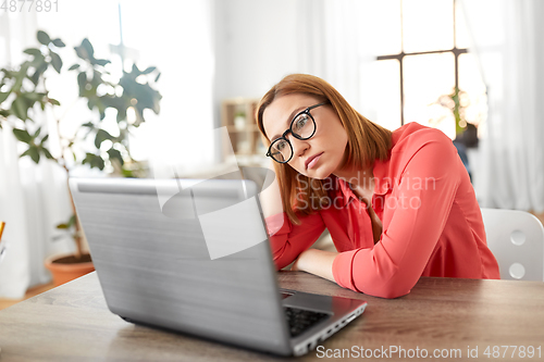 Image of bored woman with laptop working at home office