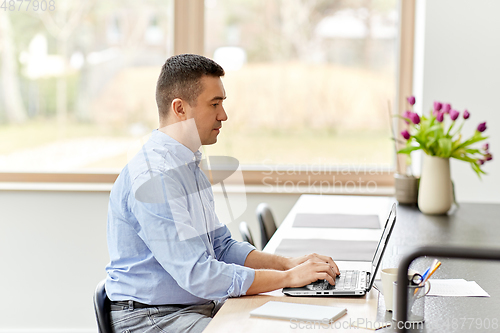 Image of man with laptop working at home office