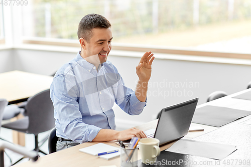 Image of man with laptop having video call at home office