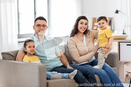 Image of portrait of happy family sitting on sofa at home