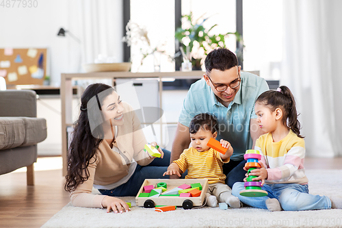 Image of happy family palying with wooden toys at home