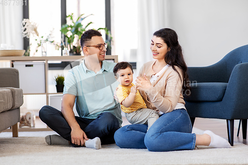 Image of happy family with child sitting on floor at home