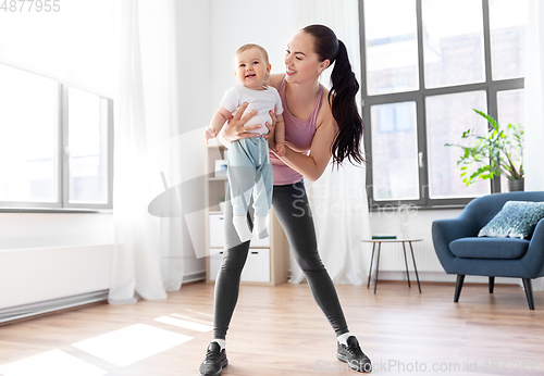 Image of happy mother with little baby exercising at home