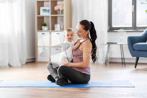 Image of happy mother with little baby at home