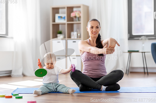 Image of happy mother with little baby exercising at home