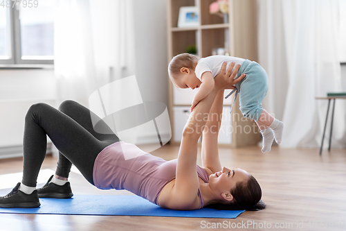 Image of happy mother with little baby exercising at home