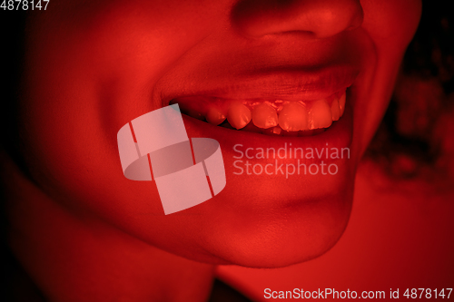 Image of Beautiful african-american woman portrait isolated on red studio background in neon light, monochrome