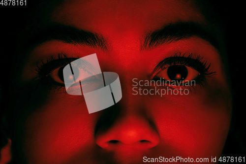 Image of Beautiful african-american woman portrait isolated on red studio background in neon light, monochrome