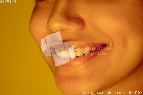 Image of Beautiful african-american woman portrait isolated on yellow studio background in neon light, monochrome